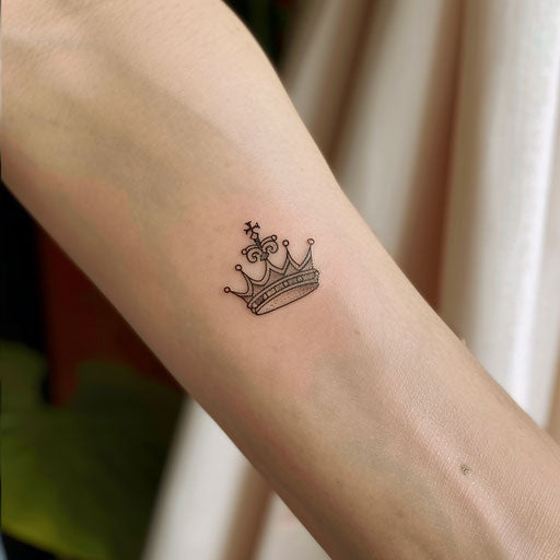 Minimalist king's crown tattoo with simple lines and a touch of gold