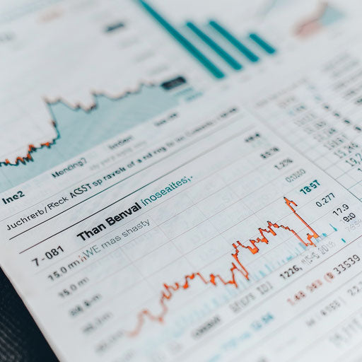 A close-up of a financial newspaper with stock prices and market trends