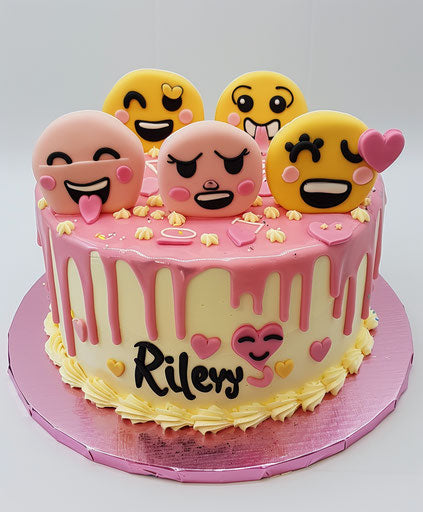 Pink and yellow cake with various emoticons on top