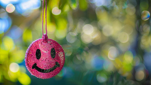 Pink smiling face charm hanging on blurry background