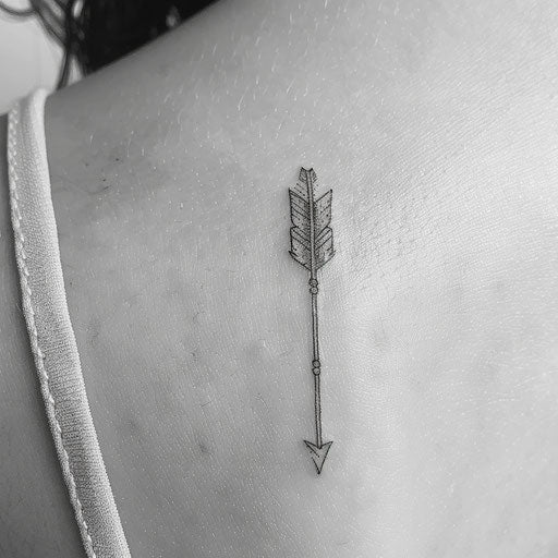 Minimalistic black ink arrow tattoo on white canvas