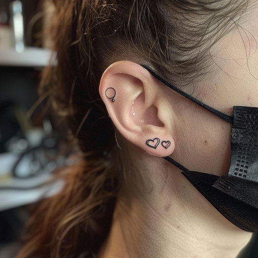 Ear tattoos with minimalist hearts in the style of Ami James