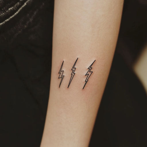 Small matching tattoos of tiny lightning bolts in the style of Humberto Ramos