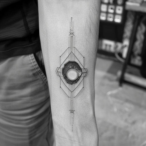 Modern tattoo of a black pearl in a geometric hexagon