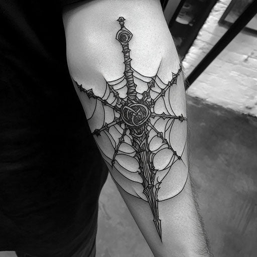 Elbow spider web tattoo with medieval weaponry