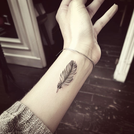 Feather wrist tattoo in the style of Peter Jackson