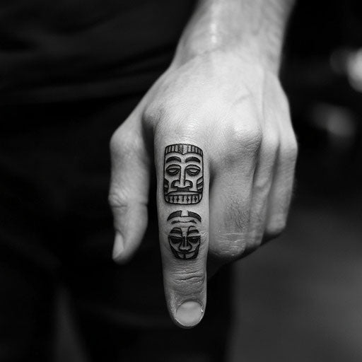 Tiny finger tattoos in the style of Adrian Smith with small tribal masks