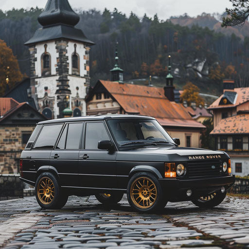 Vintage 1995 Range Rover with matte black finish and brass accents in an old European village