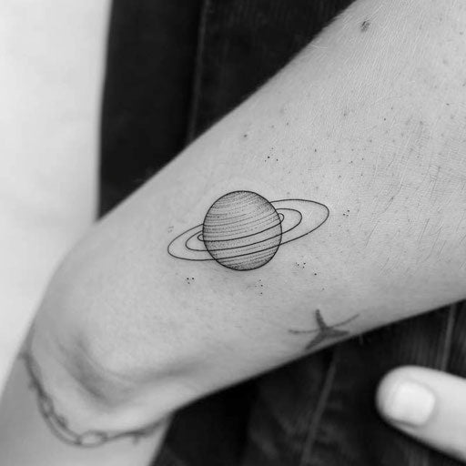 Minimalist tattoo of a small planet with rings
