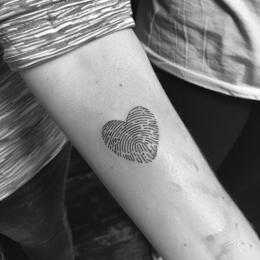 Detailed fingerprint heart tattoo in traditional American style on white background
