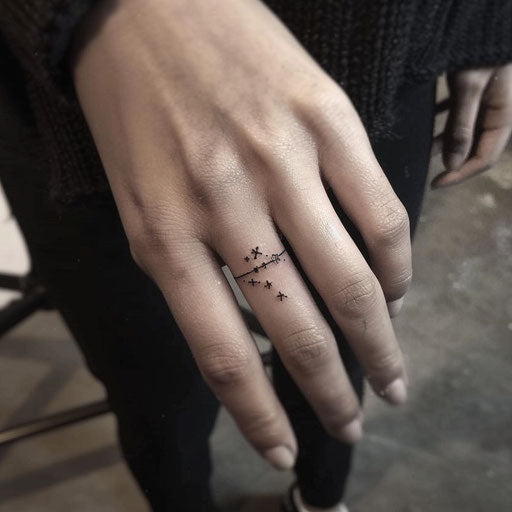 Wedding ring tattoo with constellation design on finger