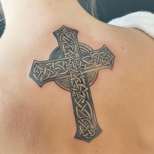 Elaborate Celtic cross tattoo on white surface