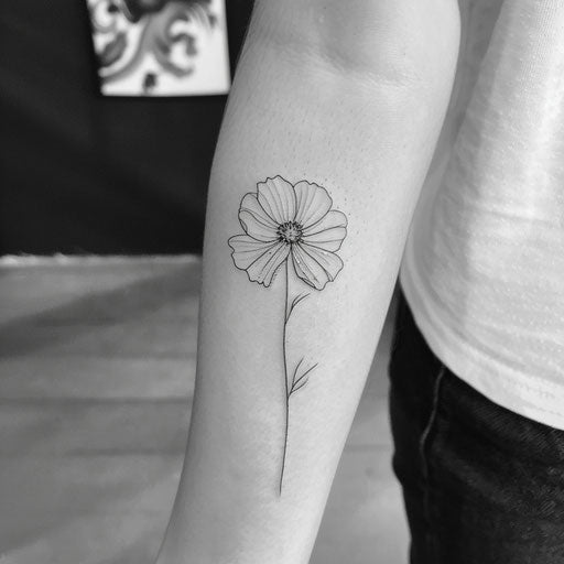 Simplistic yet striking tattoo sketch of a cosmos flower in bold monochrome