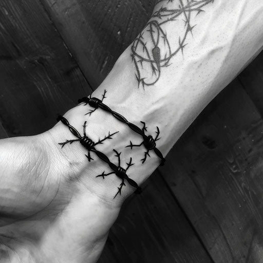 Bold flat tattoo sketch of a wrist band with barbed wire details