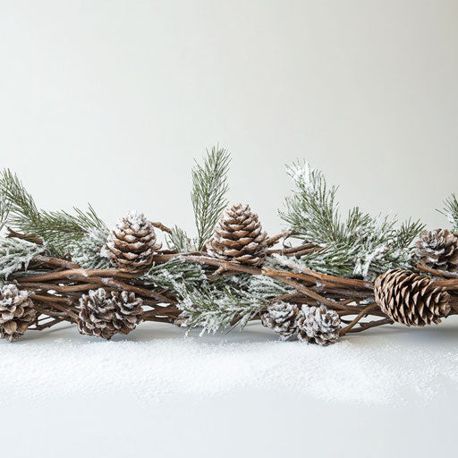 Rustic border of woven pine branches and pinecones dusted with snow