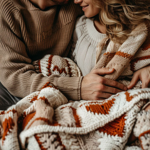Couple sharing warm knitted blanket