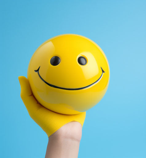 Yellow smile on blue background with fingers showing a smile
