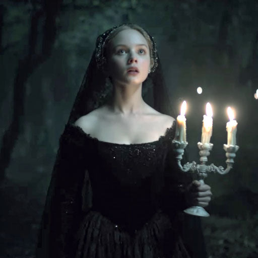 Elegant woman in a dark forest with a candelabra